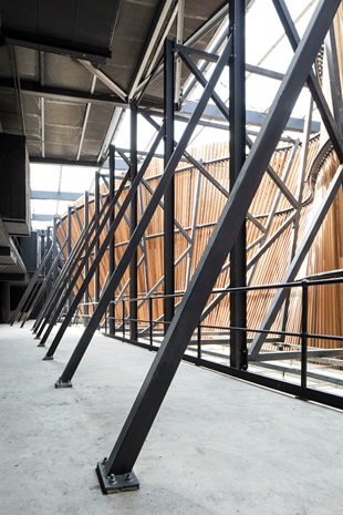 A steel frame supports the impressive timber wave which crests above the retail spaces
